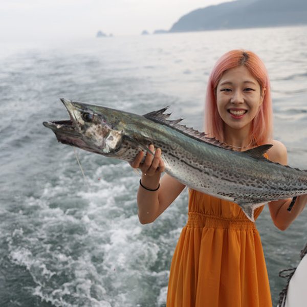 요트 위에서 낚은 물고기를 든 손님